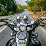 Man riding motorcycle and travelling on an empty country road.